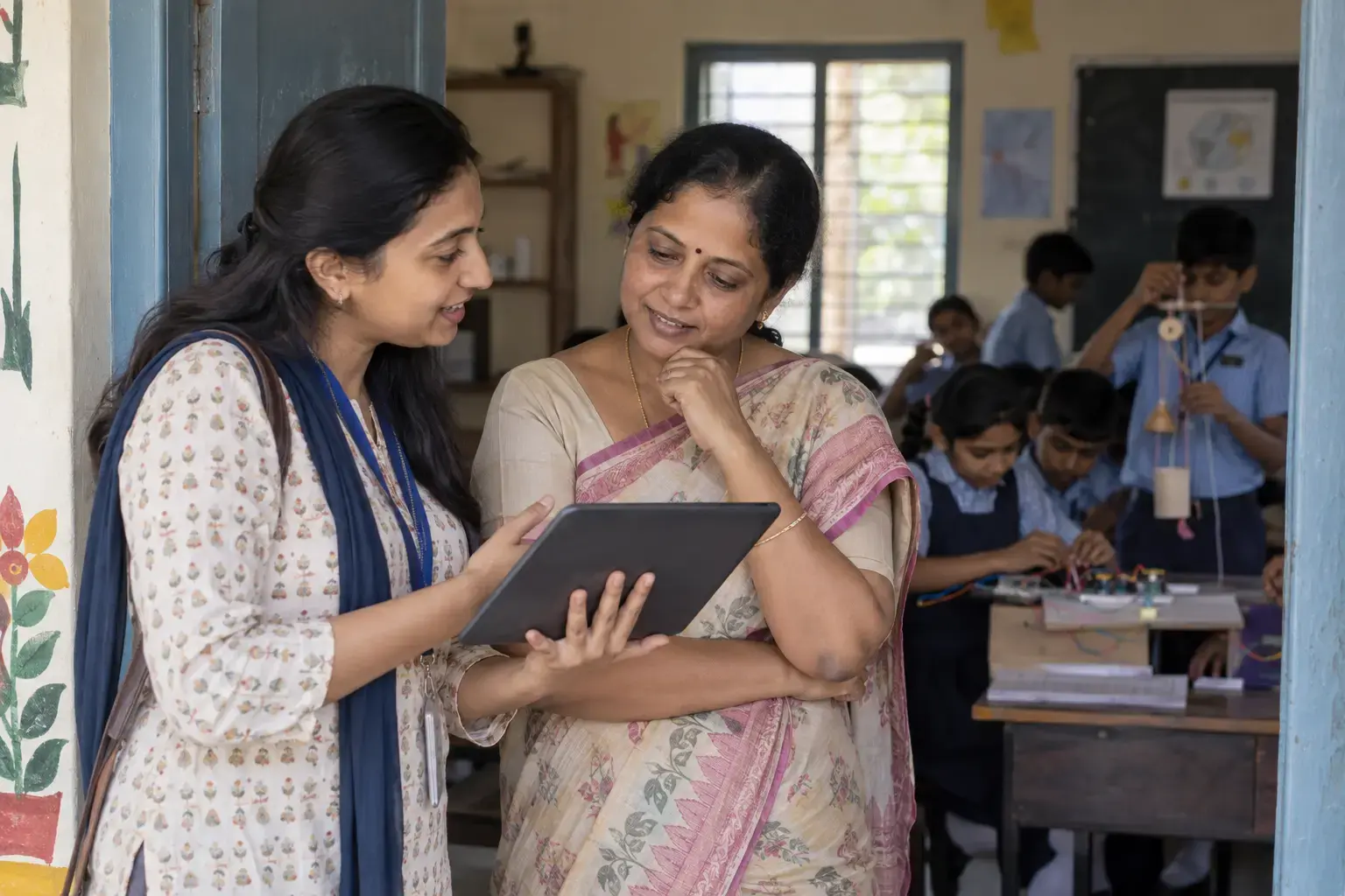 An NGO coordinator and schoolteacher discussing a learning programme in an Indian school